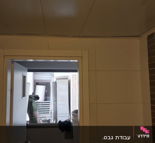 קיר גבס עם דלת פתוחה וחדר אחסון